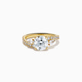 The Star Lab Grown Diamond Vine Ring in 18K Yellow Gold features a large round lab diamond and smaller diamonds along a split shank, beautifully displayed against a white background.