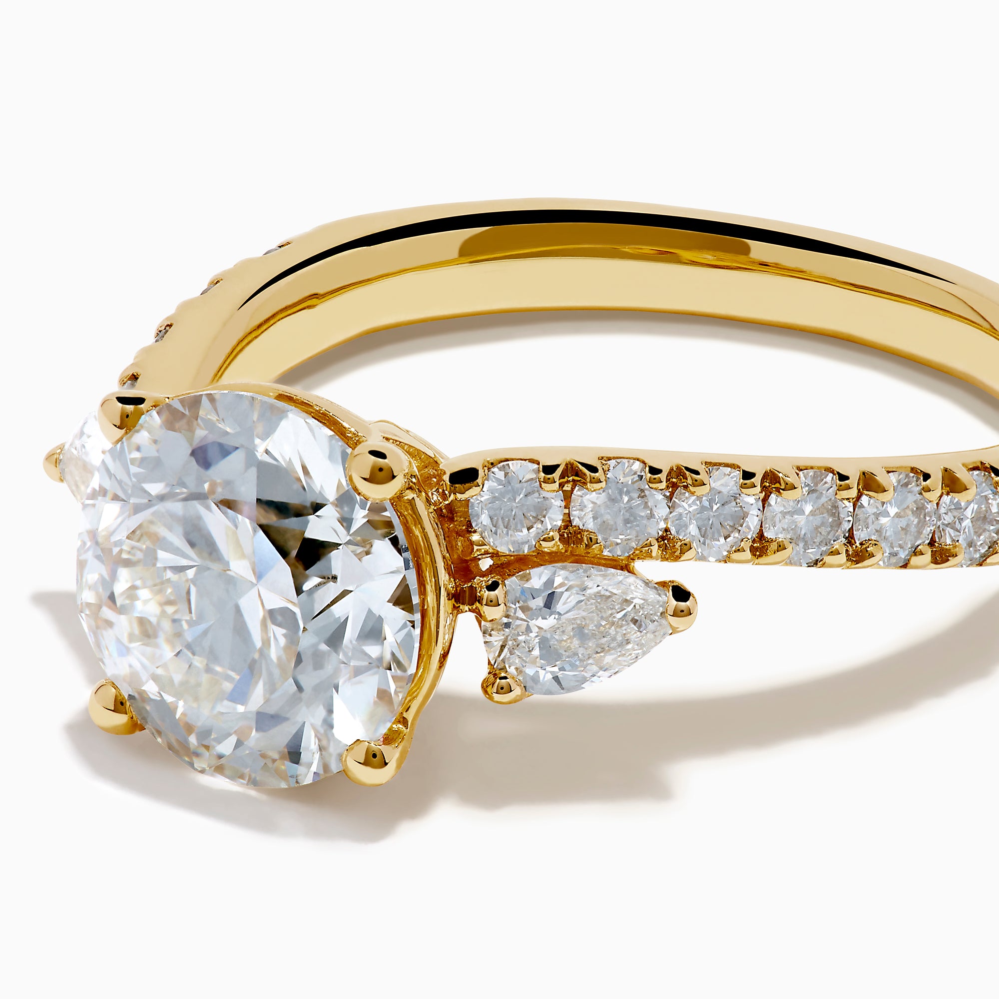 The Star Lab Grown Diamond Vine Ring in 18K Yellow Gold features a large round lab diamond and smaller diamonds along a split shank, beautifully displayed against a white background.