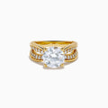 The Star Lab Grown Diamond Embrace Ring in 18K Yellow Gold showcases a prominent round lab-grown diamond center, with rows of smaller diamonds along the band and detailed side designs.