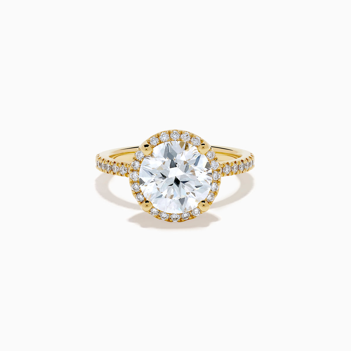 The Star Lab Grown Diamond Halo Ring in 18K Yellow Gold showcases a large oval lab diamond center, encircled by a halo of star lab diamonds and additional diamonds along the band for extra brilliance.
