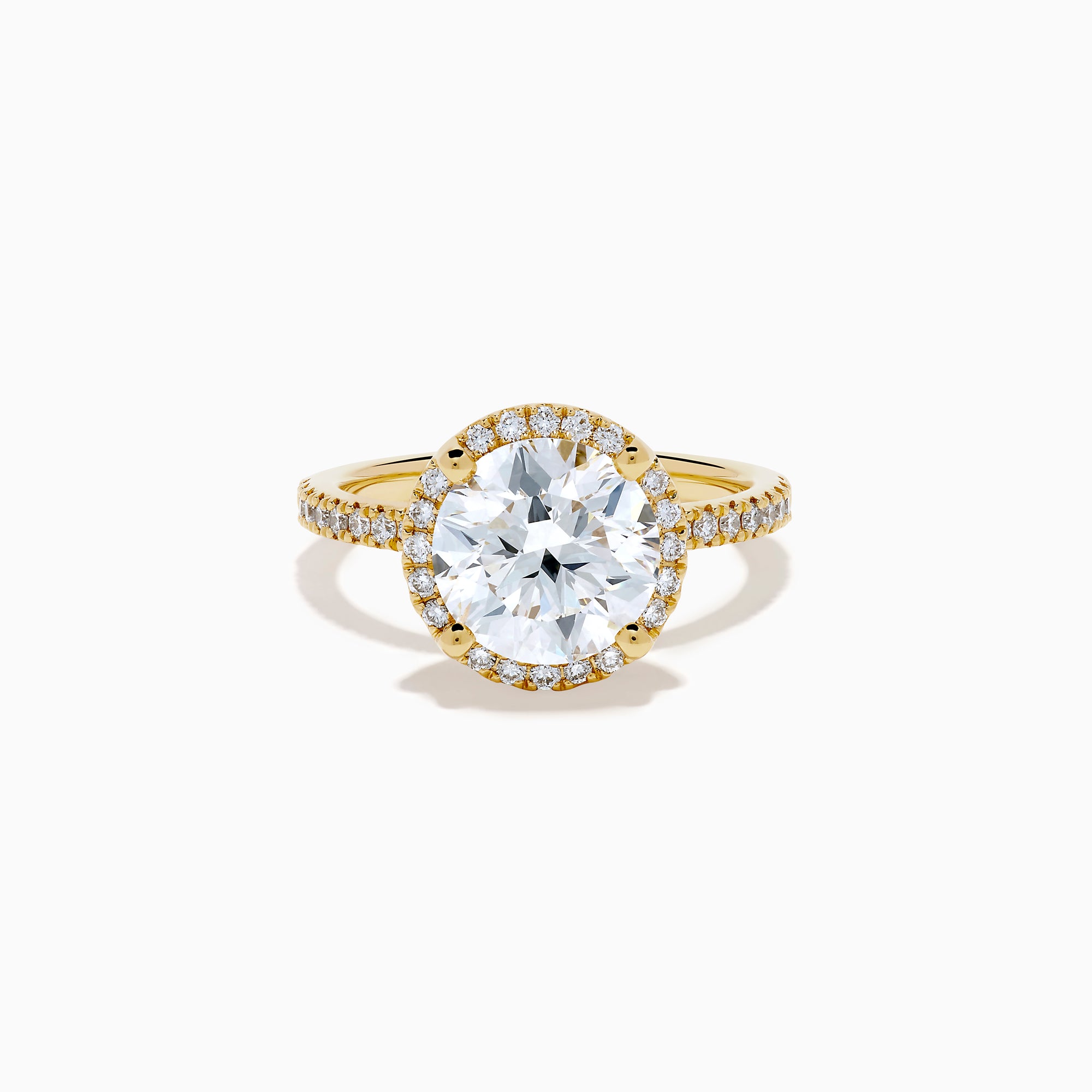 The Star Lab Grown Diamond Halo Ring in 18K Yellow Gold showcases a large oval lab diamond center, encircled by a halo of star lab diamonds and additional diamonds along the band for extra brilliance.