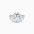 The Star Lab Grown Diamond Fleur Ring in 18K White Gold showcases a large round center lab diamond, with a sparkling halo of smaller diamonds and extra diamonds set along the band.