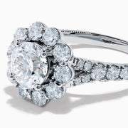 The Star Lab Grown Diamond Fleur Ring in 18K White Gold showcases a large round center lab diamond, with a sparkling halo of smaller diamonds and extra diamonds set along the band.