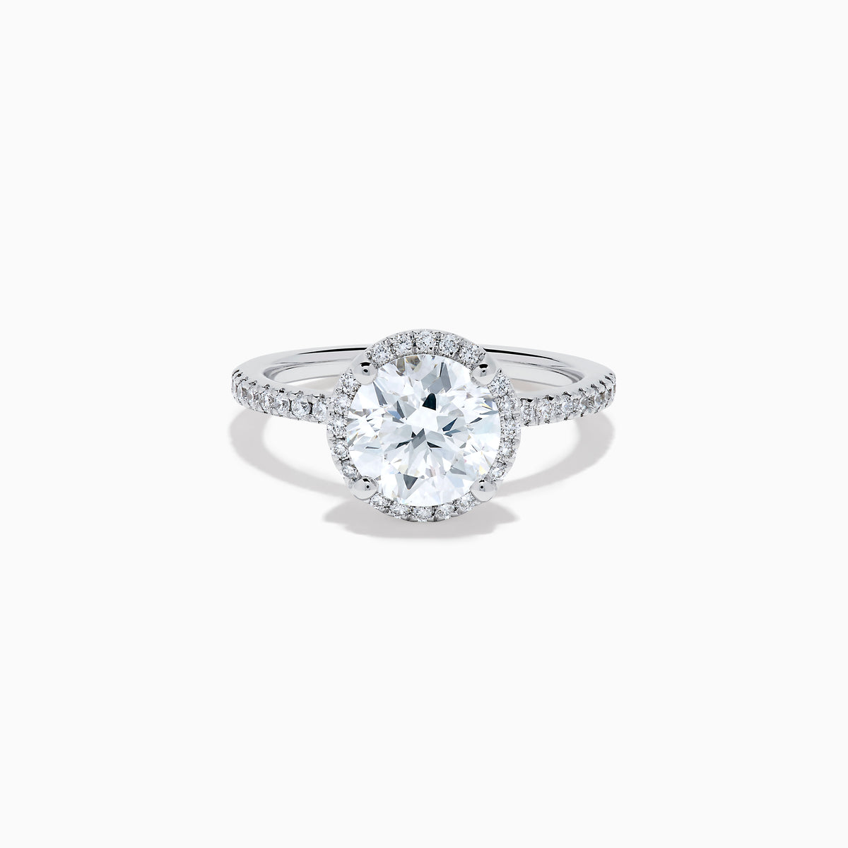 The Star Lab Grown Diamond Halo Ring in 18K White Gold features a large round lab diamond center, encircled by a sparkling halo and delicate stones on the band, shown against a white background.