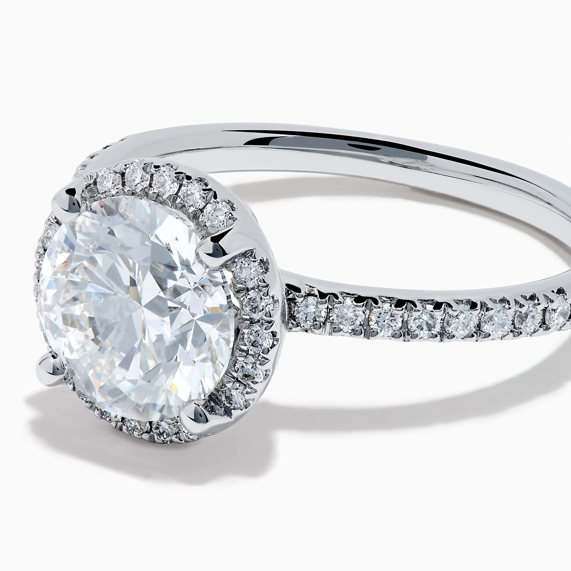 The Star Lab Grown Diamond Halo Ring in 18K White Gold features a large round lab diamond center, encircled by a sparkling halo and delicate stones on the band, shown against a white background.