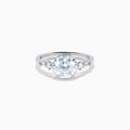 The Star Lab Grown Diamond Moderne Ring in 18K White Gold showcases a large round center diamond with two smaller diamonds on each side, set on a sleek, polished band against a white background.