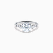 The Star Lab Grown Diamond Moderne Ring in 18K White Gold showcases a large round center diamond with two smaller diamonds on each side, set on a sleek, polished band against a white background.