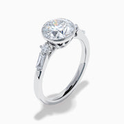The Star Lab Grown Diamond Moderne Ring in 18K White Gold showcases a large round center diamond with two smaller diamonds on each side, set on a sleek, polished band against a white background.