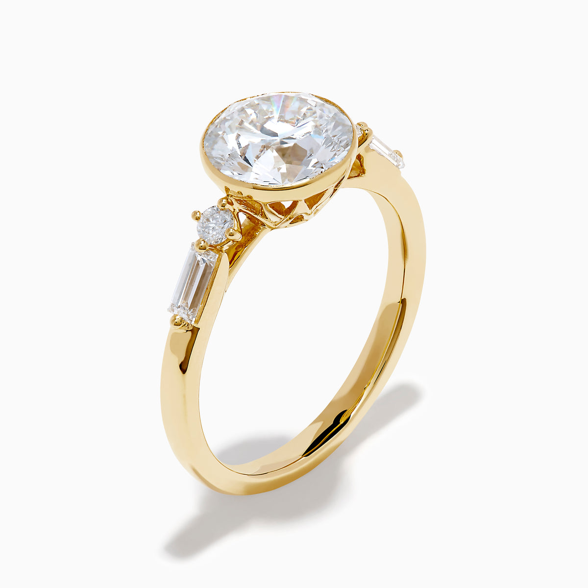 The Star Lab Grown Diamond Moderne Ring in 18K Yellow Gold features a large round lab diamond center, two smaller round diamonds, and baguette-cut side diamonds, shown on a white background.