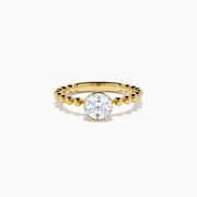 The Star Lab Grown Diamond Moderne Ring in 18K yellow gold features a beaded band and a large round lab diamond at its center, displayed on a white background.