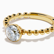 The Star Lab Grown Diamond Moderne Ring in 18K yellow gold features a beaded band and a large round lab diamond at its center, displayed on a white background.