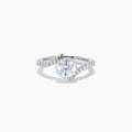 The Star Lab Grown Diamond Connect Ring in 18K White Gold showcases a striking round center stone, with an elegantly twisting band highlighted by sparkling side diamonds for extra brilliance.