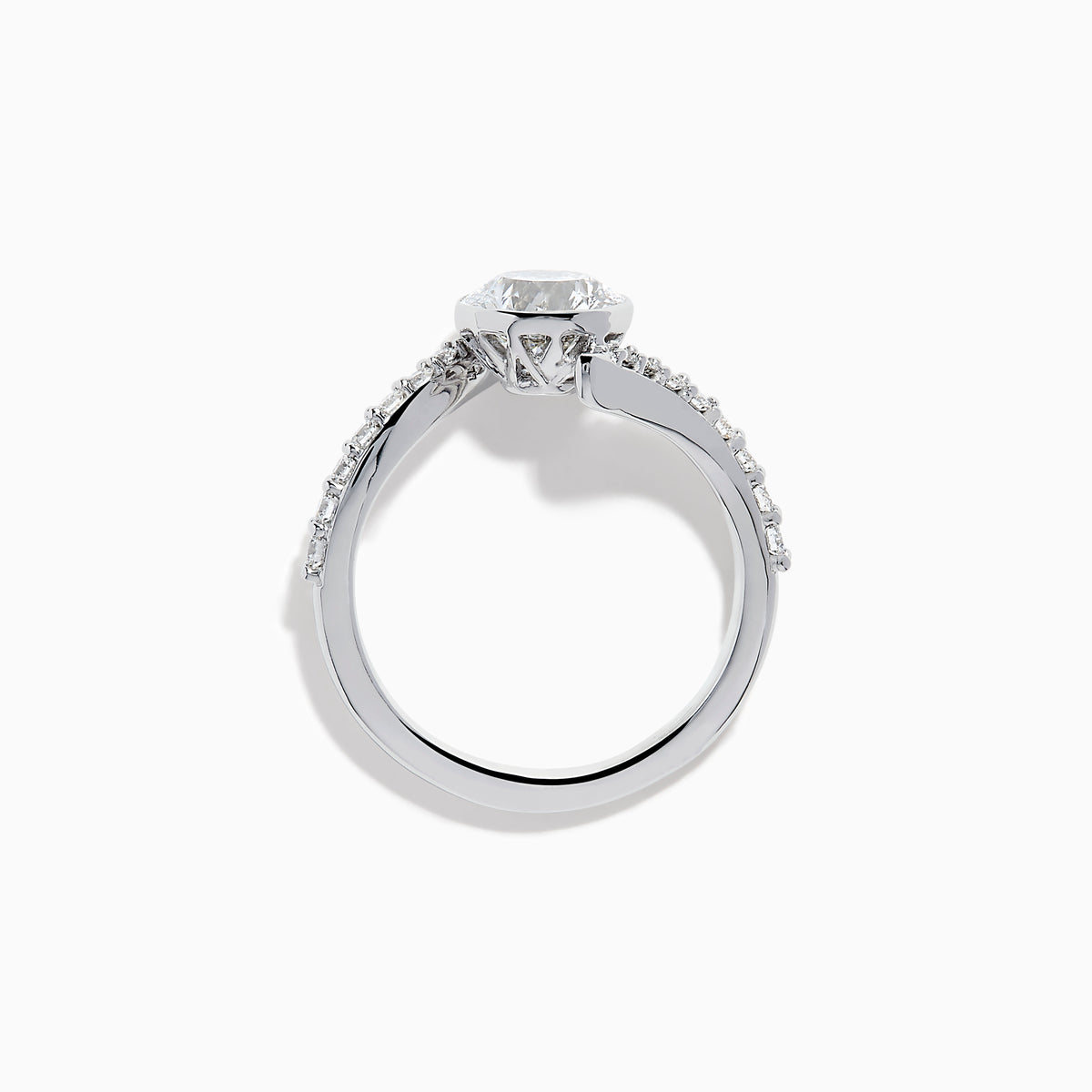 The Star Lab Grown Diamond Connect Ring in 18K White Gold showcases a striking round center stone, with an elegantly twisting band highlighted by sparkling side diamonds for extra brilliance.