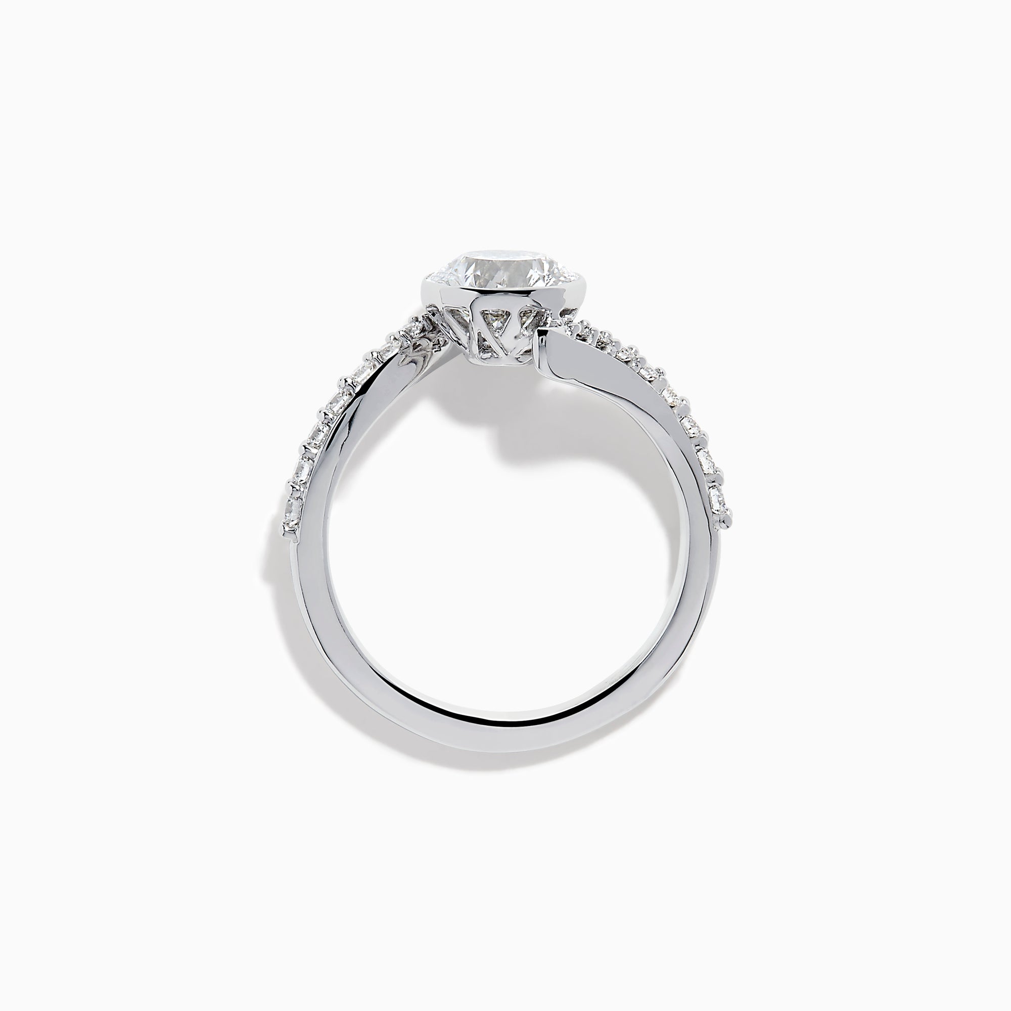 The Star Lab Grown Diamond Connect Ring in 18K White Gold showcases a striking round center stone, with an elegantly twisting band highlighted by sparkling side diamonds for extra brilliance.