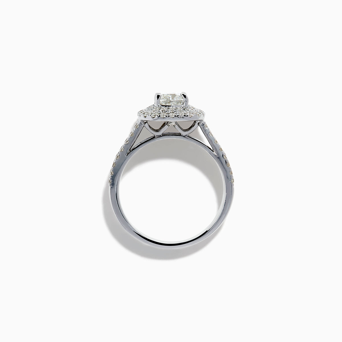 The 18K White Gold Diamond Double Halo Ring showcases a cushion-cut center diamond, surrounded by a double halo and accented with diamonds along the elegant split shank band.