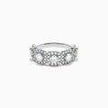 The 18K White Gold Diamond Round Halo Band Ring showcases three central round diamonds, each with a diamond halo, and features rectangular diamond accents on the sides for added brilliance.