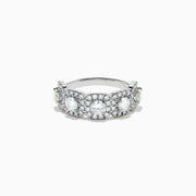 The 18K White Gold Diamond Round Halo Band Ring showcases three central round diamonds, each with a diamond halo, and features rectangular diamond accents on the sides for added brilliance.