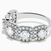 The 18K White Gold Diamond Round Halo Band Ring showcases three central round diamonds, each with a diamond halo, and features rectangular diamond accents on the sides for added brilliance.