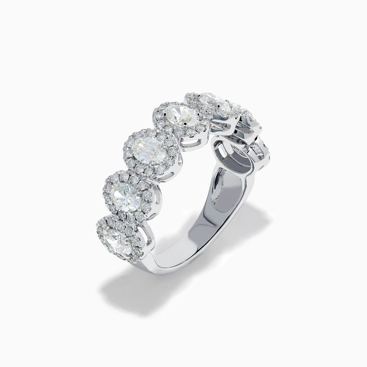 The 18K White Gold Diamond Oval Halo Band Ring showcases large oval-cut diamonds, each surrounded by a sparkling halo of smaller stones, elegantly displayed on a white background.