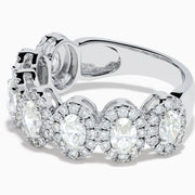 The 18K White Gold Diamond Oval Halo Band Ring showcases large oval-cut diamonds, each surrounded by a sparkling halo of smaller stones, elegantly displayed on a white background.