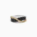 The 14K Two-Tone Gold Black and White Diamond Crossover Ring showcases two rows of black diamonds crossed diagonally by a wavy line of white stones set in gold.