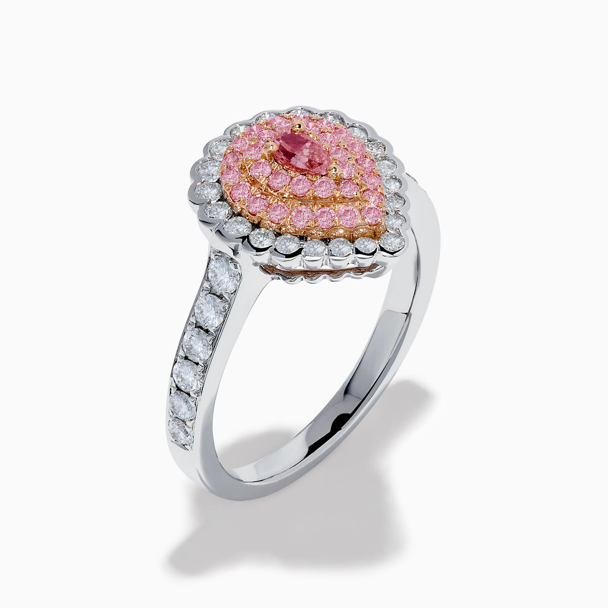 The 18K Two Tone Gold Pink and White Diamond Ring features a teardrop-shaped pink diamond cluster encircled by white diamonds, set on a two-tone gold band adorned with additional diamonds.