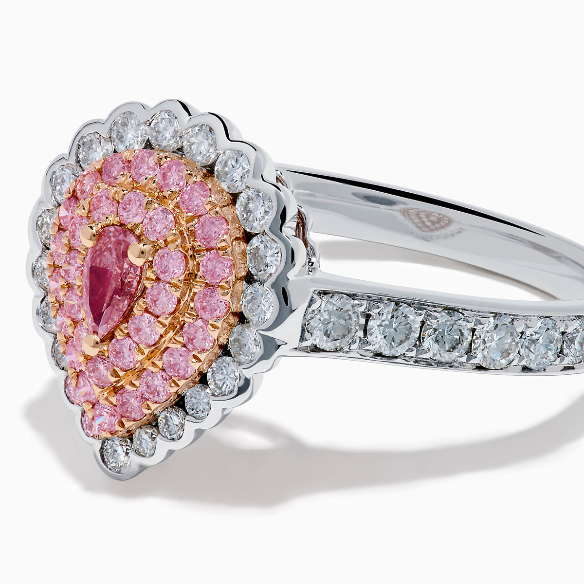 The 18K Two Tone Gold Pink and White Diamond Ring features a teardrop-shaped pink diamond cluster encircled by white diamonds, set on a two-tone gold band adorned with additional diamonds.