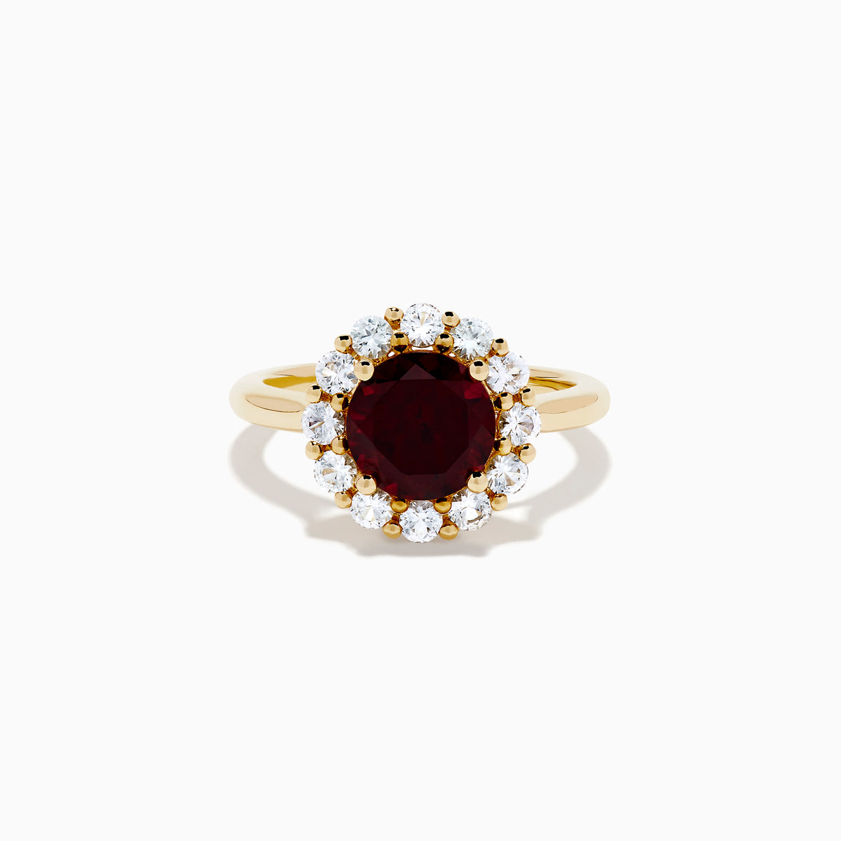 The 14K Yellow Gold Garnet and White Sapphire Halo Ring showcases a vibrant round garnet center, surrounded by sparkling white sapphires, set in yellow gold and displayed on a white background.