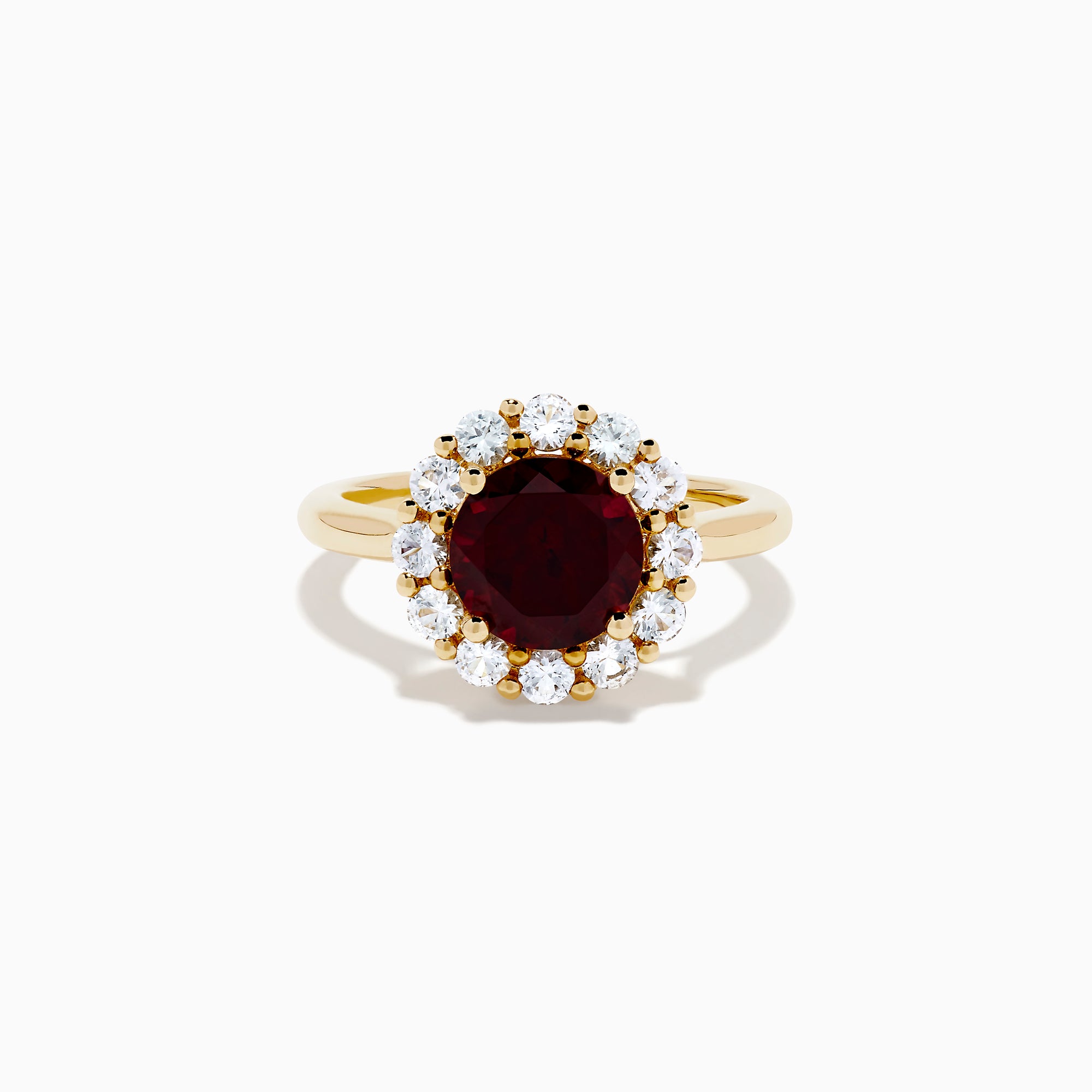 The 14K Yellow Gold Garnet and White Sapphire Halo Ring showcases a vibrant round garnet center, surrounded by sparkling white sapphires, set in yellow gold and displayed on a white background.