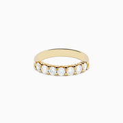 The 14K Yellow Gold 7-Stone Prong Set Diamond Band showcases a row of seven oval-cut white diamonds, totaling 1.00 TCW, displayed on a plain white background.