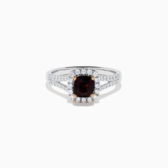 The 18K White Gold GIA Certified Alexandrite and Diamond Ring showcases a cushion-cut Alexandrite surrounded by white diamonds. Its split band is adorned with diamonds, adding elegance, and the ring is displayed against a plain white background.