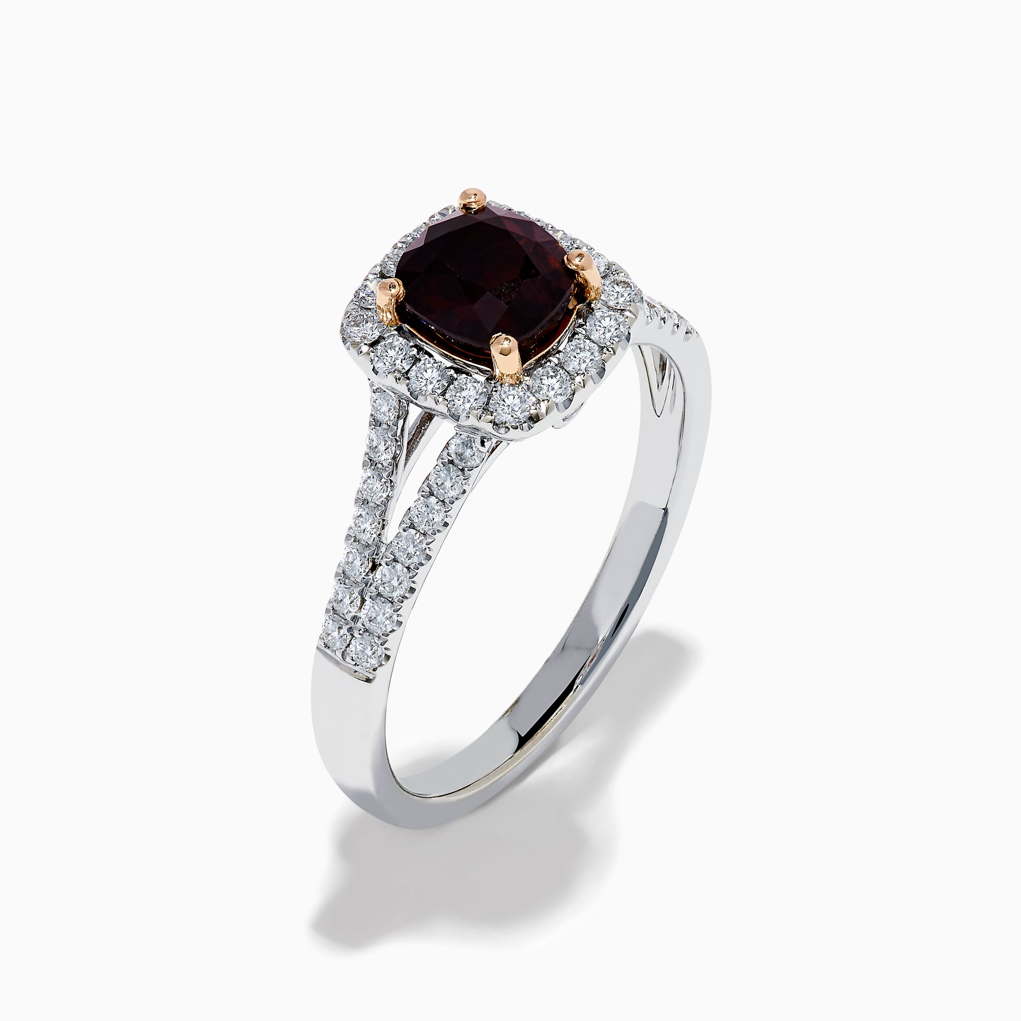 The 18K White Gold GIA Certified Alexandrite and Diamond Ring showcases a cushion-cut Alexandrite surrounded by white diamonds. Its split band is adorned with diamonds, adding elegance, and the ring is displayed against a plain white background.
