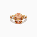 The 14K Rose Gold Morganite and Diamond Twist Band Ring features an oval peach morganite center stone with rows of white diamonds on a unique twist band, shown against a white background.