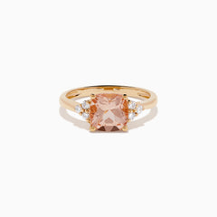 A beautiful 14K Rose Gold Cushion Solitaire Morganite and Diamond Ring featuring a large peach cushion-cut morganite center stone, accented by three round white diamonds on each side.