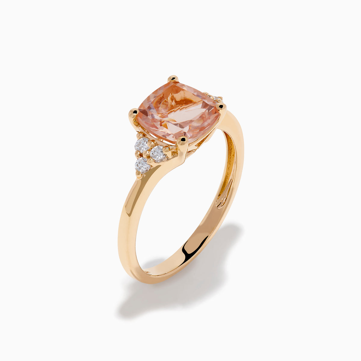 A beautiful 14K Rose Gold Cushion Solitaire Morganite and Diamond Ring featuring a large peach cushion-cut morganite center stone, accented by three round white diamonds on each side.