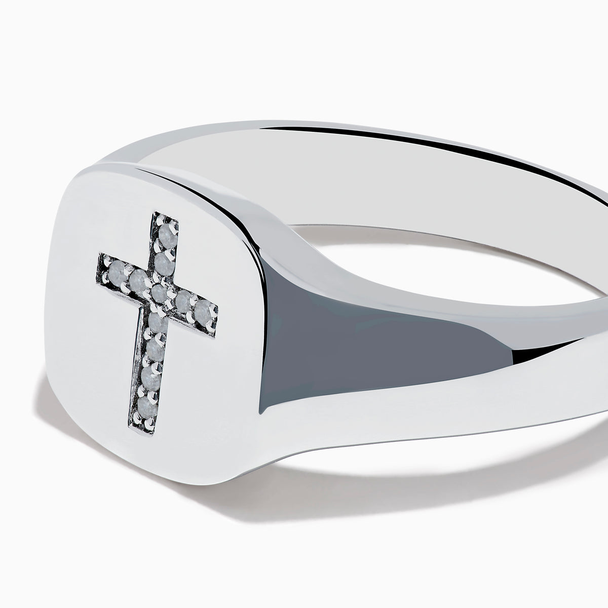 The 925 Sterling Silver Diamond Cross Ring features a flat, oval top with a raised diamond cross set with small white stones against a black background, creating a simple and elegant design.