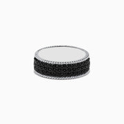 The Mens 925 Sterling Silver Black Sapphire Ring features a round, smooth, reflective top and sides adorned with small black sapphires, presented against a white background.