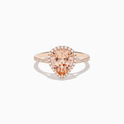 The Blush 14K Rose Gold Morganite and Diamond Ring features a large pear-shaped morganite framed by a halo of sparkling diamonds, with additional diamonds set along the band for added brilliance.