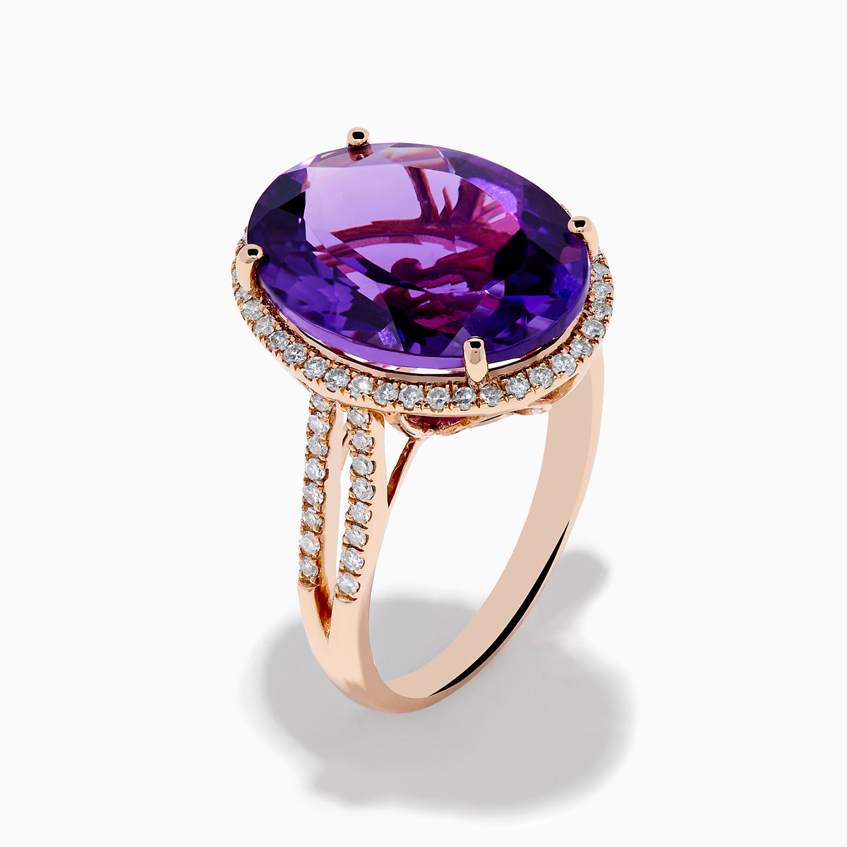 The 14K Rose Gold Amethyst and Diamond Ring showcases an oval amethyst with a diamond halo set on a rose gold band, displayed against a plain white background.