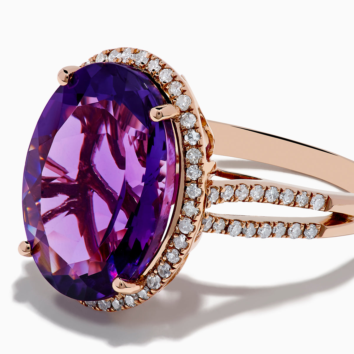 The 14K Rose Gold Amethyst and Diamond Ring showcases an oval amethyst with a diamond halo set on a rose gold band, displayed against a plain white background.
