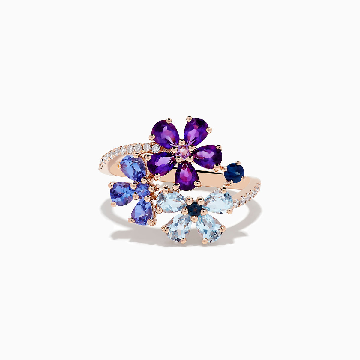 A 14K Gold Blue Topaz, Amethyst, Tanzanite, Sapphire and Diamond Ring featuring two floral designs with purple, blue, and light blue gemstones on a band adorned with small diamonds, set against a plain white background.