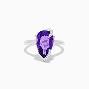 The 14K White Gold Amethyst and Diamond Ring features a large pear-shaped amethyst accented by small diamonds in a curved design, shown on a plain white background.
