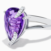 The 14K White Gold Amethyst and Diamond Ring features a large pear-shaped amethyst accented by small diamonds in a curved design, shown on a plain white background.
