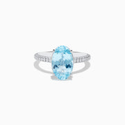 The 14K White Gold Aquamarine and Diamond Double Hidden Halo Ring features an oval-cut aquamarine center with small round diamonds along the band, shown on a white background.