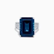 The Ocean Bleu 14K White Gold London Blue Topaz and Diamond Cocktail Ring showcases a large emerald-cut blue topaz set with four prongs, accented by sparkling diamonds along the band.