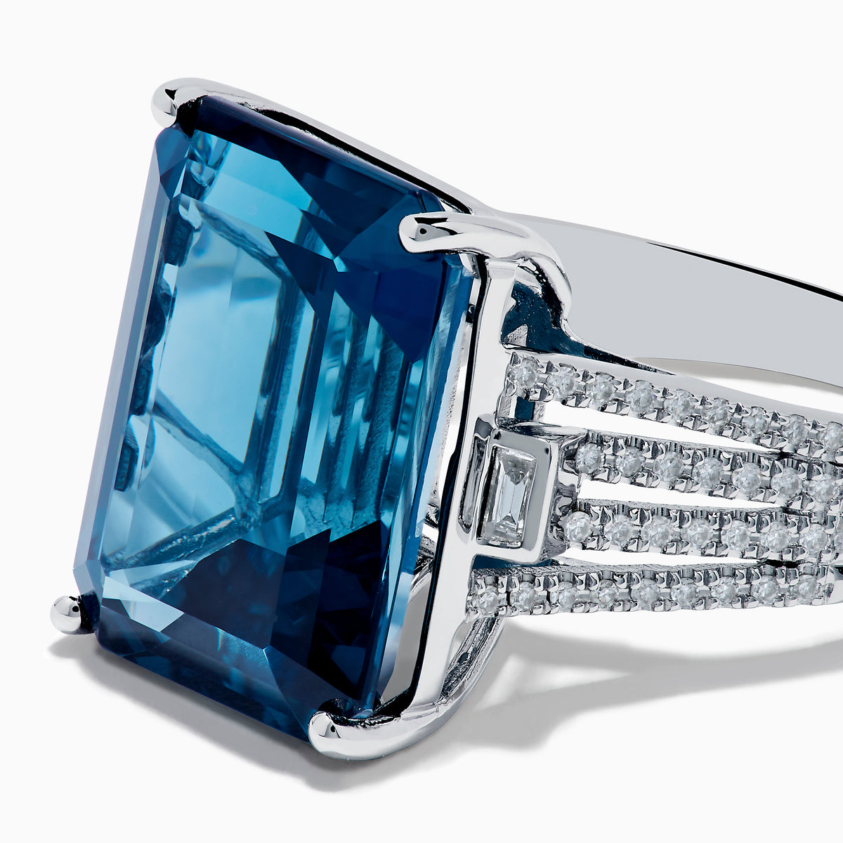 The Ocean Bleu 14K White Gold London Blue Topaz and Diamond Cocktail Ring showcases a large emerald-cut blue topaz set with four prongs, accented by sparkling diamonds along the band.