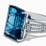 The Ocean Bleu 14K White Gold London Blue Topaz and Diamond Cocktail Ring showcases a large emerald-cut blue topaz set with four prongs, accented by sparkling diamonds along the band.