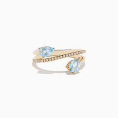 The Aquarius 14K Yellow Gold Aquamarine and Diamond Ring features two pear-shaped light blue aquamarines at each end and a spiral band partially encrusted with diamonds that wraps elegantly around the finger.