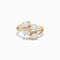 The 14K Yellow Gold Opal and Diamond Bypass Ring features three oval white opals and sparkling accent diamonds along a split band, shown against a white background.