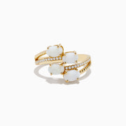 The 14K Yellow Gold Opal and Diamond Bypass Ring features three oval white opals and sparkling accent diamonds along a split band, shown against a white background.